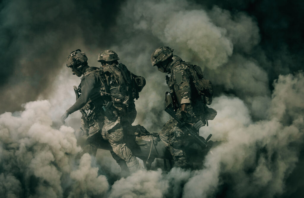 Army Soldiers carrying patient to the aircraft between smoke in